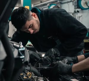 Equipa de mecânicos a trabalhar no motor do carro, representa os serviços de manutenção e reparo oferecidos pela ok! seguros para garantir a segurança e o bom funcionamento dos veículos dos seus clientes